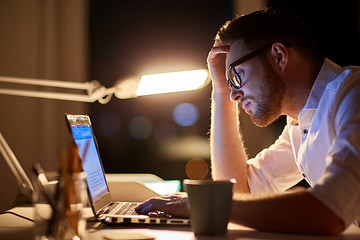 Image showing businessman typing on laptop at night office