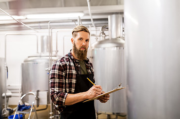 Image showing man with clipboard at craft brewery or beer plant