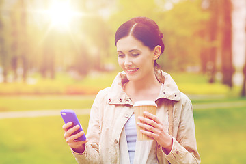 Image showing smiling woman with smartphone and coffee in park