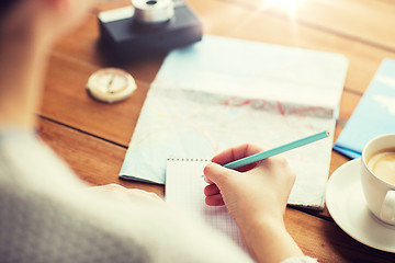 Image showing close up of traveler hands with notepad and pencil