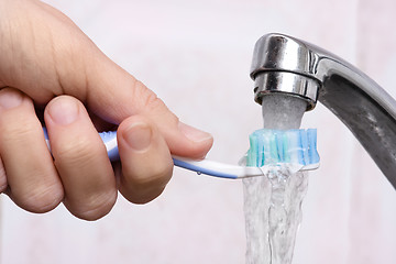 Image showing hand washing toothbrush under running water