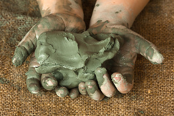 Image showing blue clay in the hands of child