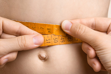 Image showing hands measured waist with tape measure