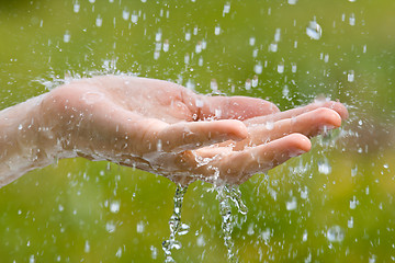 Image showing hand of woman catching raindrops, closeup