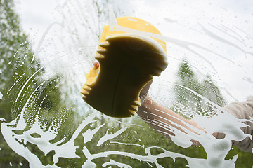 Image showing hand with sponge washing the windscreen of a car, inside view