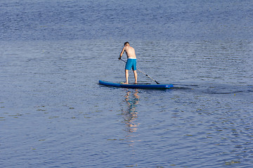 Image showing Man on Paddle Board paddling out to lake