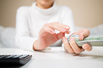 Image showing business, finance, saving, banking and people concept - close up of woman hands counting us dollar money