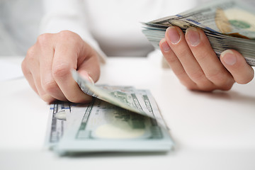 Image showing Close up of woman with calculator counting money