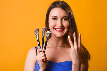 Image showing Young girl with makeup brushes
