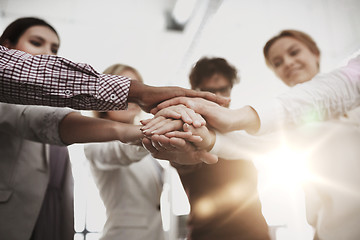 Image showing happy business team with hands on top at office