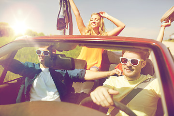 Image showing happy friends driving in cabriolet car