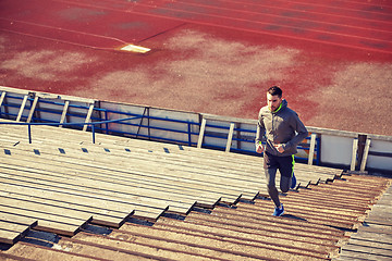 Image showing happy young man running upstairs on stadium