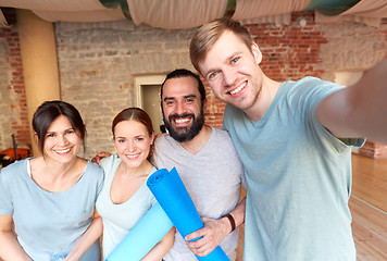 Image showing happy friends at yoga studio or gym taking selfie