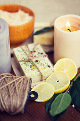 Image showing close up of natural soap and candles on wood