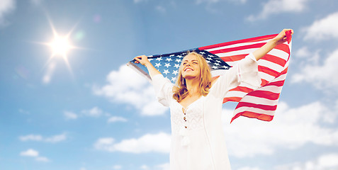 Image showing happy young woman with american flag over blue sky