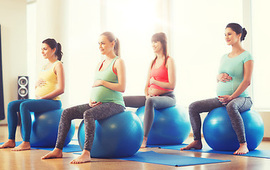 Image showing happy pregnant women exercising on fitball in gym