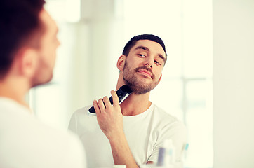 Image showing man shaving beard with trimmer at bathroom