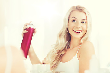 Image showing woman with hairspray styling her hair at bathroom