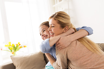 Image showing happy smiling family hugging on sofa at home