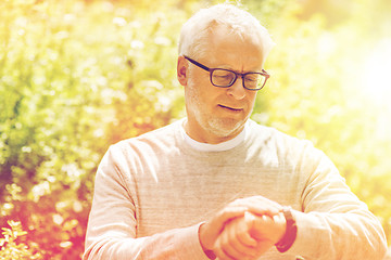 Image showing senior man checking time on his wristwatch