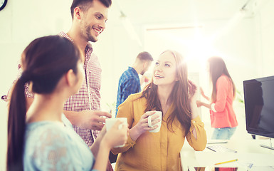 Image showing happy creative team drinking coffee at office