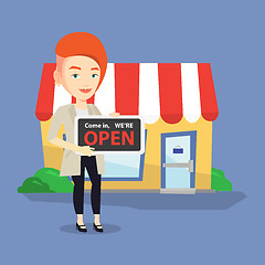 Image showing Female shop owner holding open signboard.