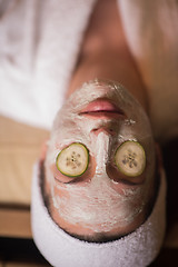 Image showing woman is getting facial clay mask at spa