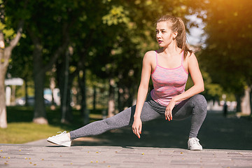 Image showing Fit fitness woman doing stretching exercises outdoors at park