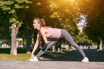 Image showing Fit fitness woman doing stretching exercises outdoors at park