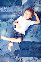 Image showing Cute little boy  the background jeans.