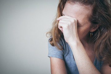 Image showing one sad woman sitting near a wall