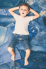 Image showing Cute little boy  the background jeans.