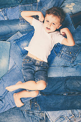 Image showing Cute little boy with sunglasses on the background jeans.