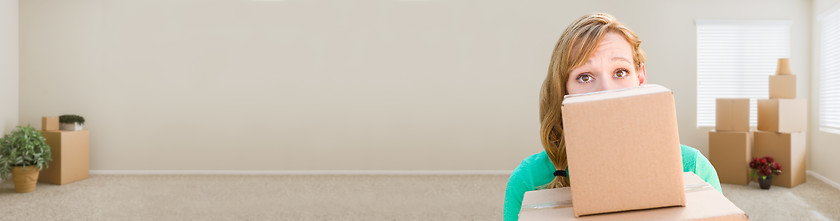 Image showing Banner of Happy Young Adult Woman Holding Moving Boxes In Empty 