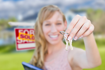 Image showing Excited Woman Holding House Keys and Sold Real Estate Sign in Fr