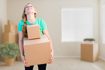 Image showing Tired Young Adult Woman Holding Moving Boxes In Empty Room In A 