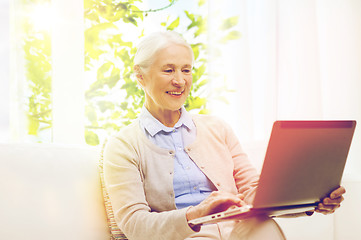 Image showing happy senior woman with laptop at home