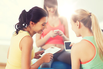 Image showing happy pregnant women with gadgets in gym