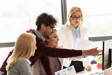 Image showing happy creative team with computer in office