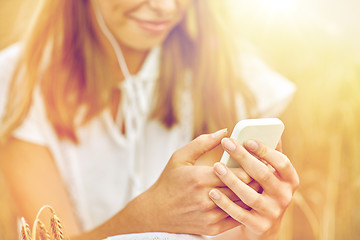 Image showing close up of woman with smartphone and earphones