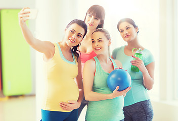 Image showing pregnant women taking selfie by smartphone in gym