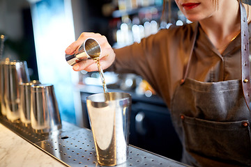 Image showing bartender with cocktail shaker and jigger at bar