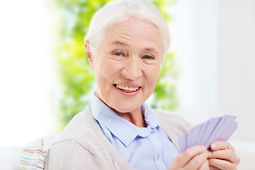 Image showing happy senior woman playing cards at home