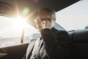 Image showing senior businessman calling on smartphone in car