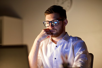 Image showing businessman in glasses with laptop at night office