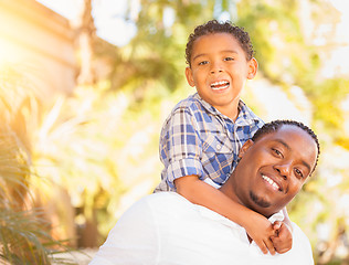 Image showing Mixed Race Son and African American Father Playing Outdoors Toge