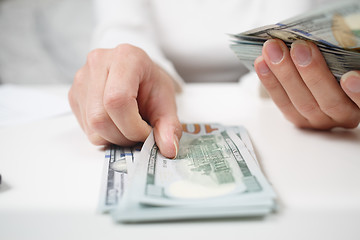 Image showing Close up of woman with calculator counting money