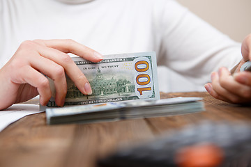 Image showing Hands hold and counting us dollar banknotes