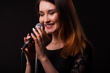 Image showing Brunette with microphone in hands