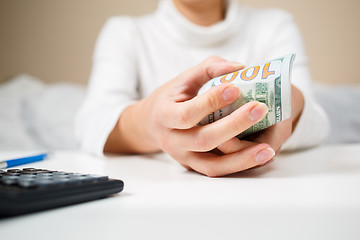 Image showing Close up of woman with calculator counting money